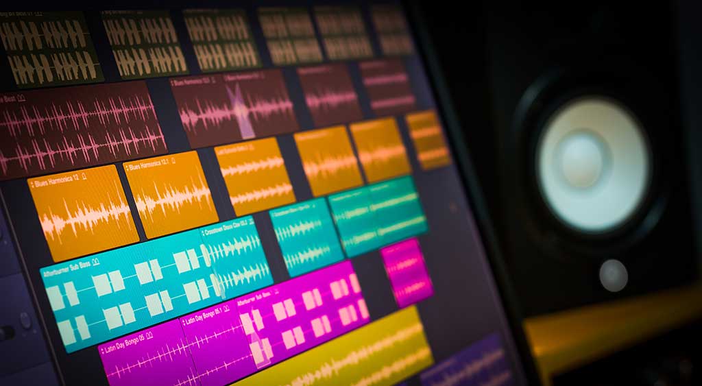 colorful digital waveform on computer monitor and studio speakers for sound recording concept